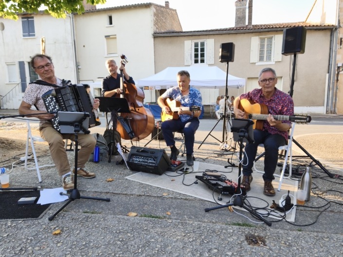 Anouman Swing Quartet à Magné Anouman Swing Quartet, quartet de swing manouche composé de deux guitaristes, un contrebassiste et un accordéoniste jouant sur la place de l'église à Magné dans les Deux-Sèvres dans le cadre du festival international de peinture en juillet 2026.