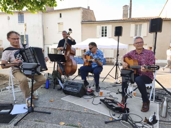 Anouman Swing Quartet Anouman Swing Quartet, quartet de swing manouche composé de deux guitaristes, un contrebassiste et un accordéoniste jouant sur la place de l'église à Magné dans les Deux-Sèvres dans le cadre du festival international de peinture en juillet 2026.