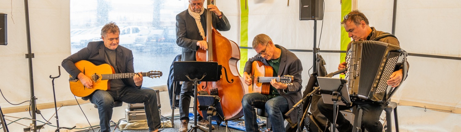 Anouman Swing Quartet en concert sous un tivoli jouant leurs morceaux de swing manouche.