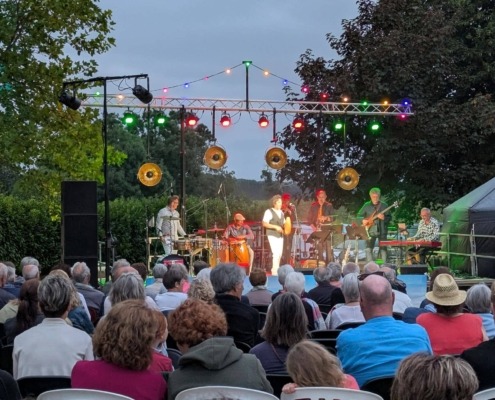 Orchestre de salsa sur scène avec du public.