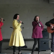 Les Salt Pin-Up's, 3 chanteuses de jazz vocal et 1 guitariste sous un préau.