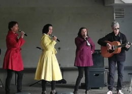 Les Salt Pin-Up's, 3 chanteuses de jazz vocal et 1 guitariste sous un préau.