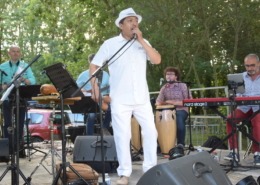 Le groupe de salsa Pacho Combo en concert sur scène en extérieur.