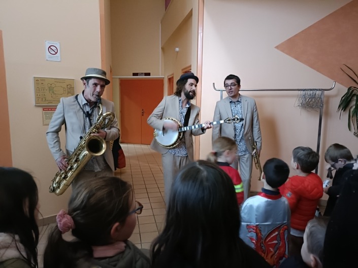 Le trio Lil'Brass Band accompagne le défilé du carnaval de l'école de Saint-Gelais tout en jouant leur répertoire musical.