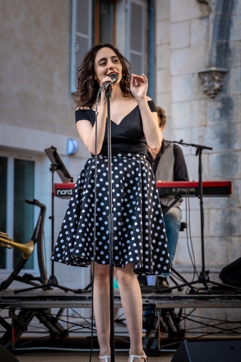 La chanteuse de The Kitchen Groovers en concert extérieur sur scène à Le Blanc (36) devant le public.
