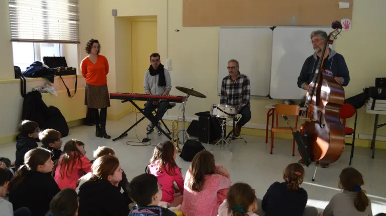Les 4 artistes du spectacle musical jeune public Une trompette dans l'espace devant des enfants à l'école.