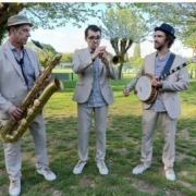 Le trio de jazz New Orleans Lil'Brass Band dans un parc jouant un morceau de jazz.