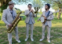 Le trio de jazz New Orleans Lil'Brass Band dans un parc jouant un morceau de jazz.