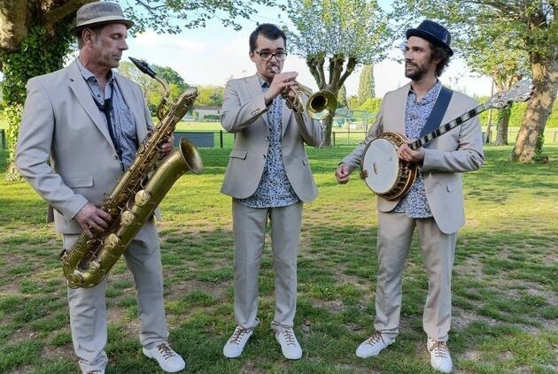 Le trio de jazz New Orleans Lil'Brass Band dans un parc jouant un morceau de jazz.