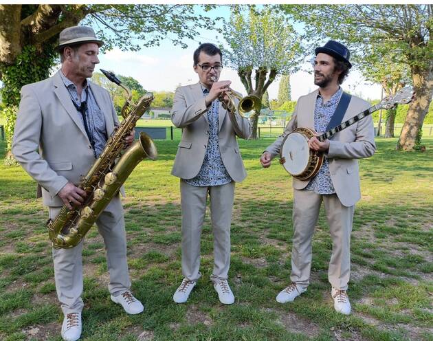 Le trio de jazz New Orleans Lil'Brass Band dans un parc jouant un morceau de jazz.